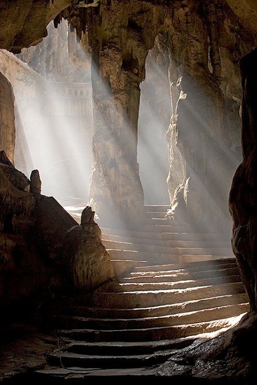 the sun shines down on some steps in a cave