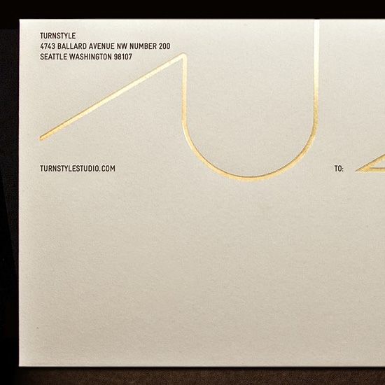 a close up of a white envelope with gold foil on the front and back of it