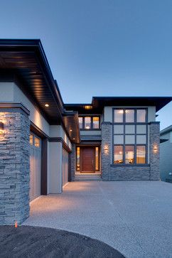 a large house with stone pillars and windows on the front of it at night time