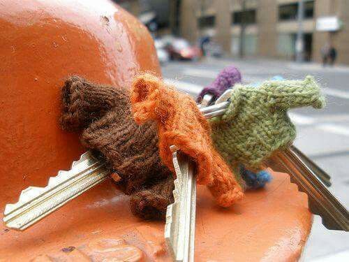 three keys are attached to the back of a fire hydrant with two stuffed animals on it