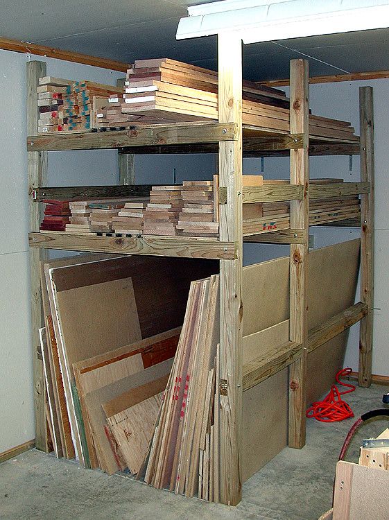 the shelves are filled with various types of boards and plywoods, including sheets of wood