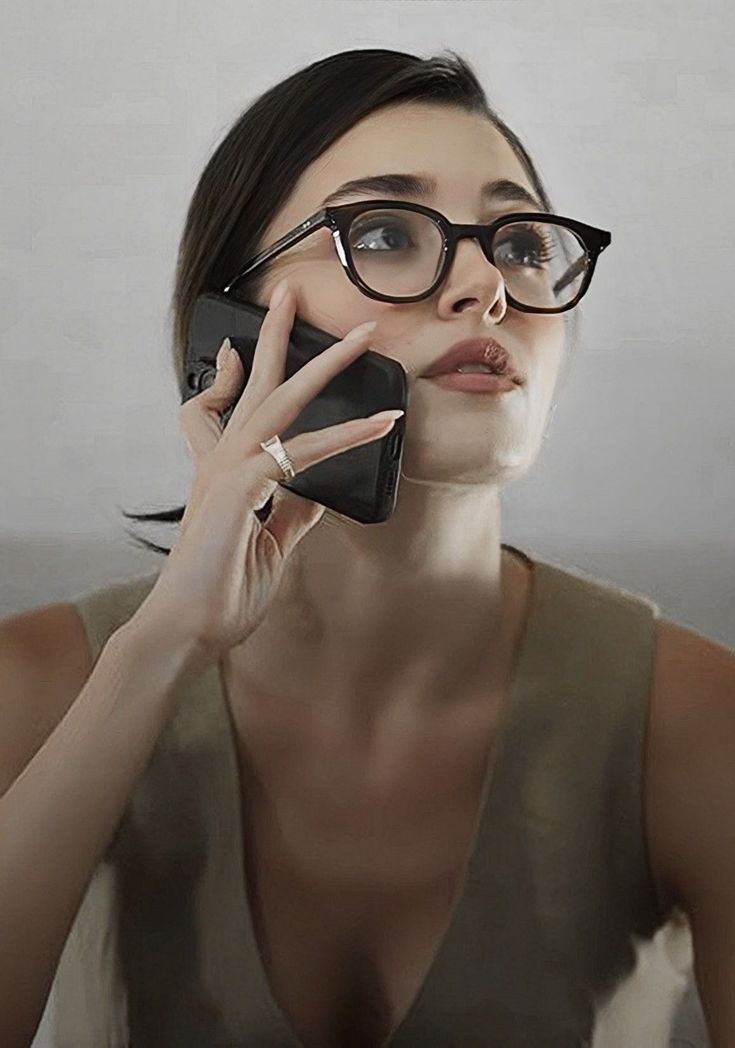 a woman wearing glasses talking on a cell phone