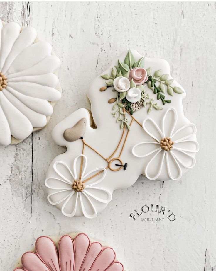 three decorated cookies with flowers on them