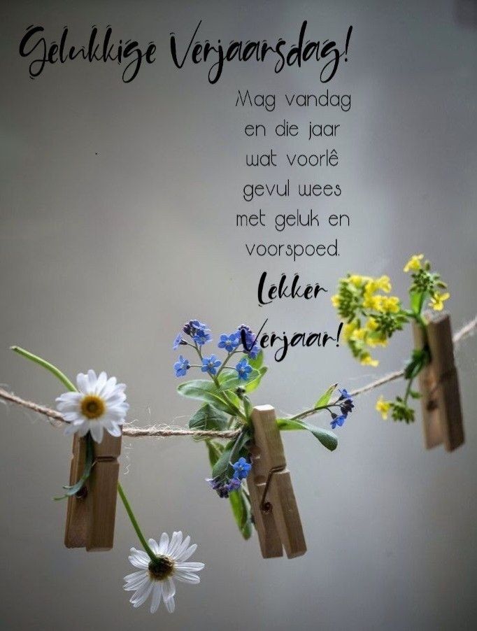 flowers are tied to clothes pins on a string with the words congratulations written in german