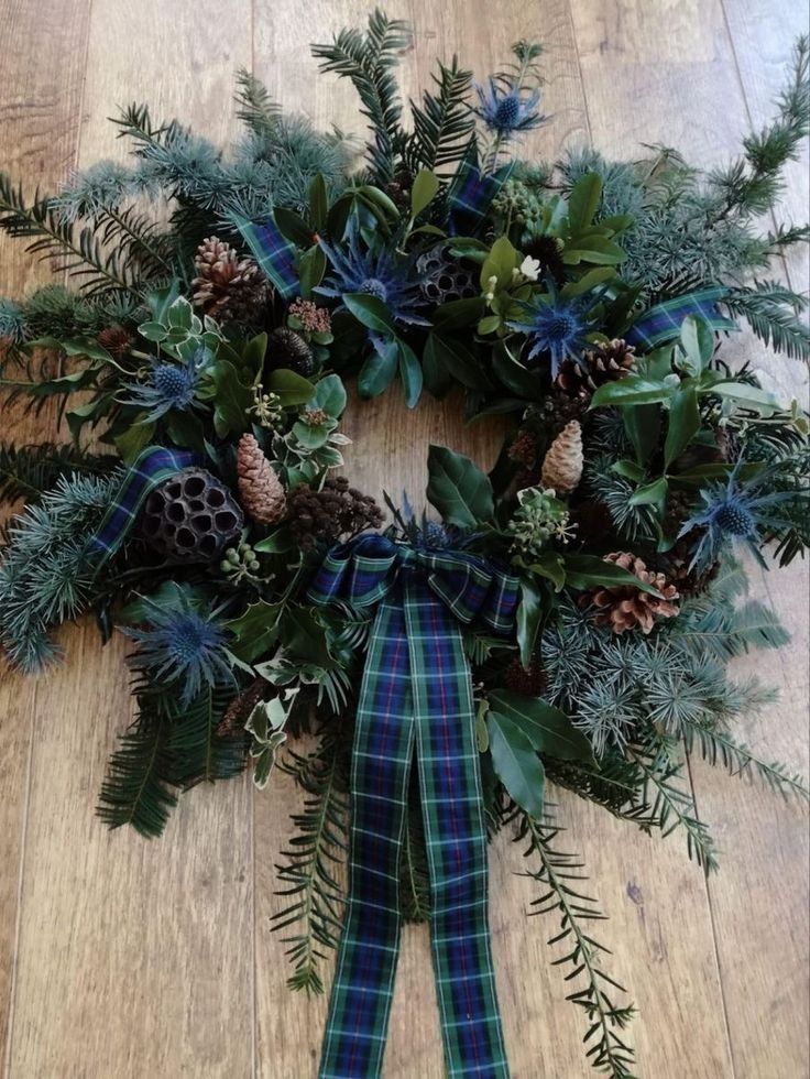 a wreath with pine cones and evergreen leaves