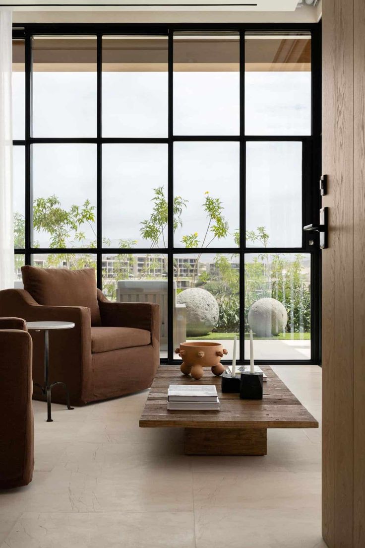 a living room with couches, tables and large glass doors leading to the outside