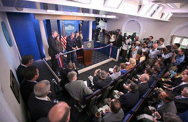 a group of people standing in front of a podium with an american flag on it