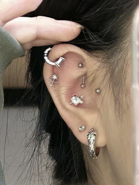 a woman wearing ear piercings with stars and moon designs on her left side of the ear