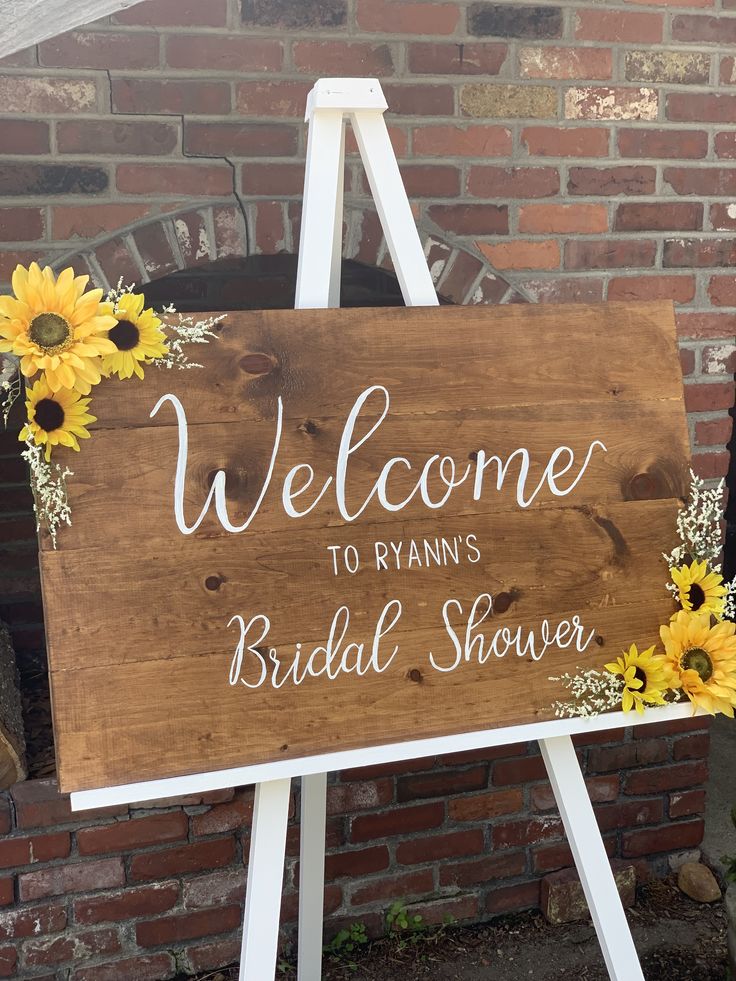 a wooden sign with sunflowers on it that says welcome to ryan's bridal shower