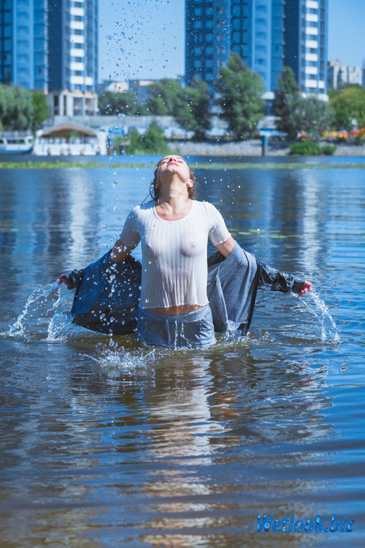 a woman is wading in the water near buildings