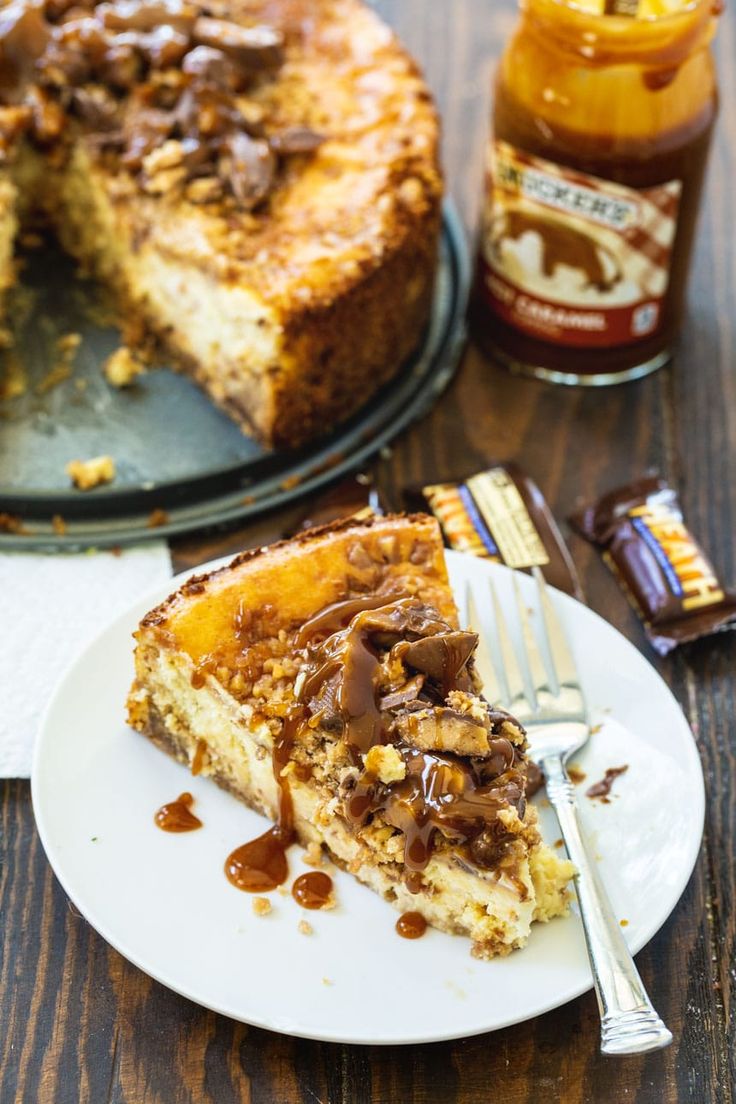 a piece of cheesecake on a plate with a fork and peanut butter jar in the background