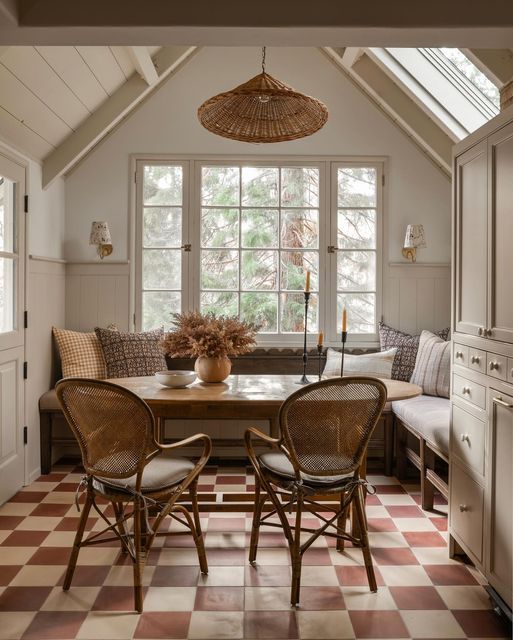 a dining room table with chairs and a bench in front of the window that is open