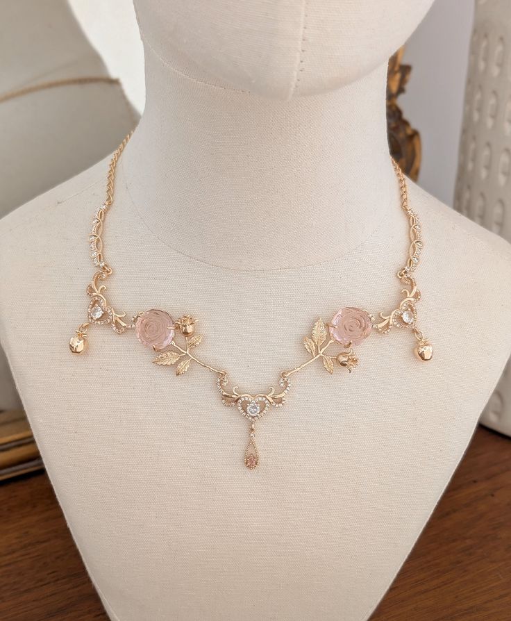 Beautifully Enchanting necklace adorned with whimsical pink roses, gold apples and crystal hearts.  A truly unique piece of jewelry to cherish for years to come.  DETAILS *Handmade in my small boutique studio. *The chain is gold filled. *Necklace measures 16" with 2" extension chain (Please message me if you with for the chain length to be extended or made shorter)  *Your necklace will arrive securely in a necklace jewelry box. Please use this box when not wearing your necklace to avoid it getti Feminine Rose Gold Jewelry With Rose Design, Charming Gold Wedding Jewelry, Feminine Rose Design Necklaces For Wedding, Feminine Rose Design Necklace For Wedding, Feminine Rose Design Wedding Necklace, Charming Rose Gold Jewelry For Wedding, Charming Rose Gold Wedding Jewelry, Gold Fairycore Jewelry Gift, Fairycore Necklace