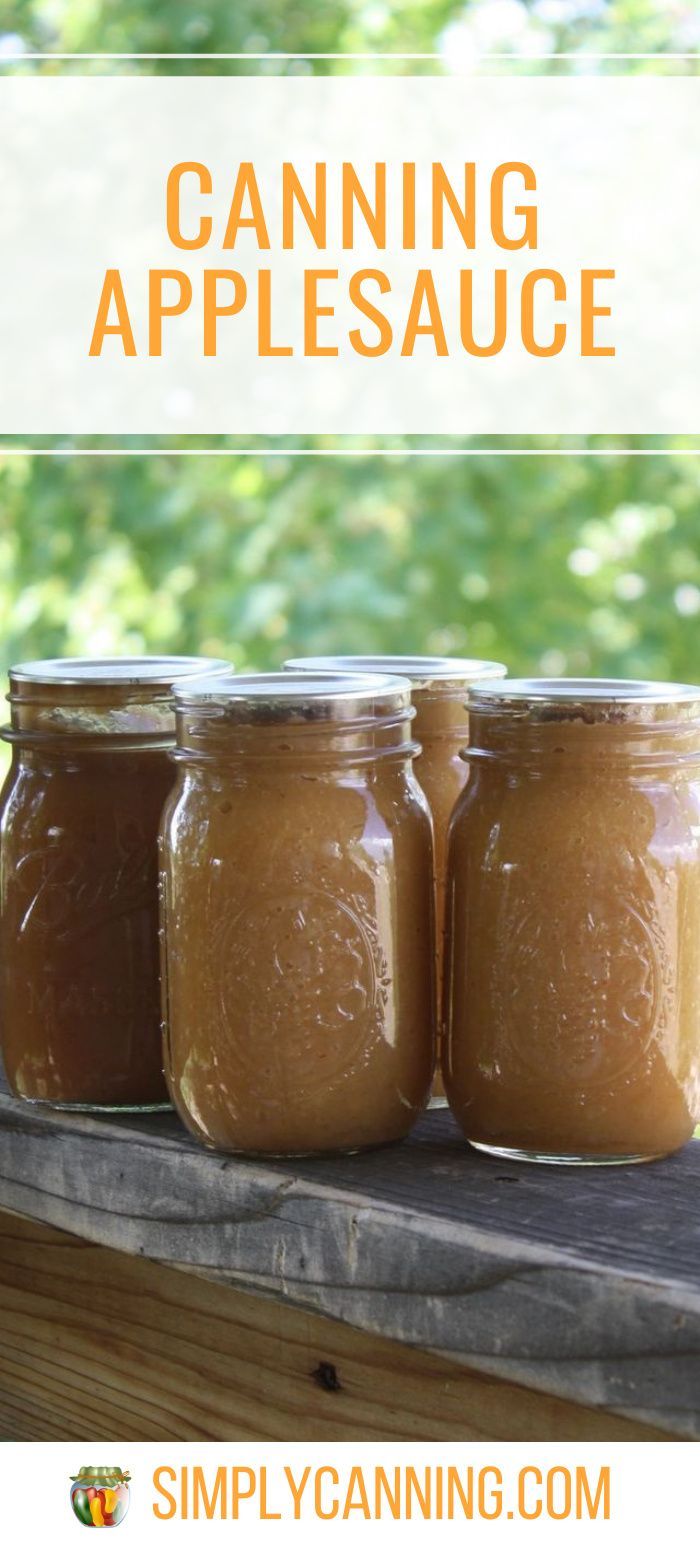 three jars filled with peanut butter sitting on top of a wooden table next to trees