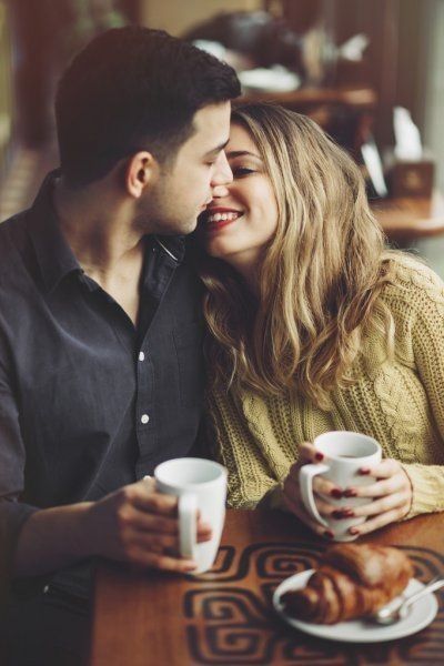 a man and woman sitting at a table with coffee cups