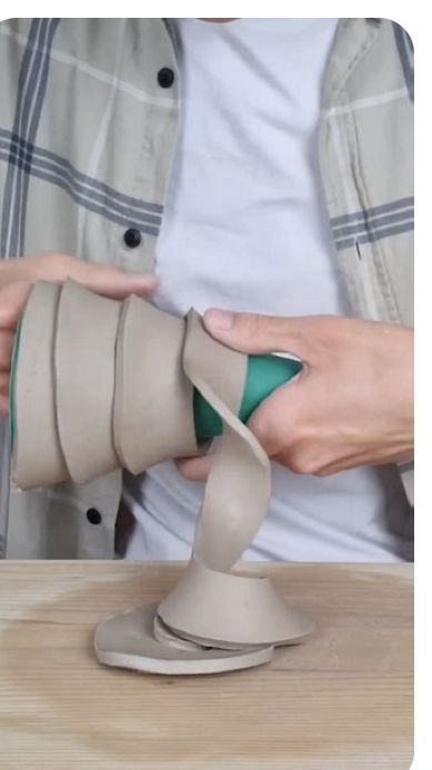 a person is using an object to make it look like a cone with a green handle