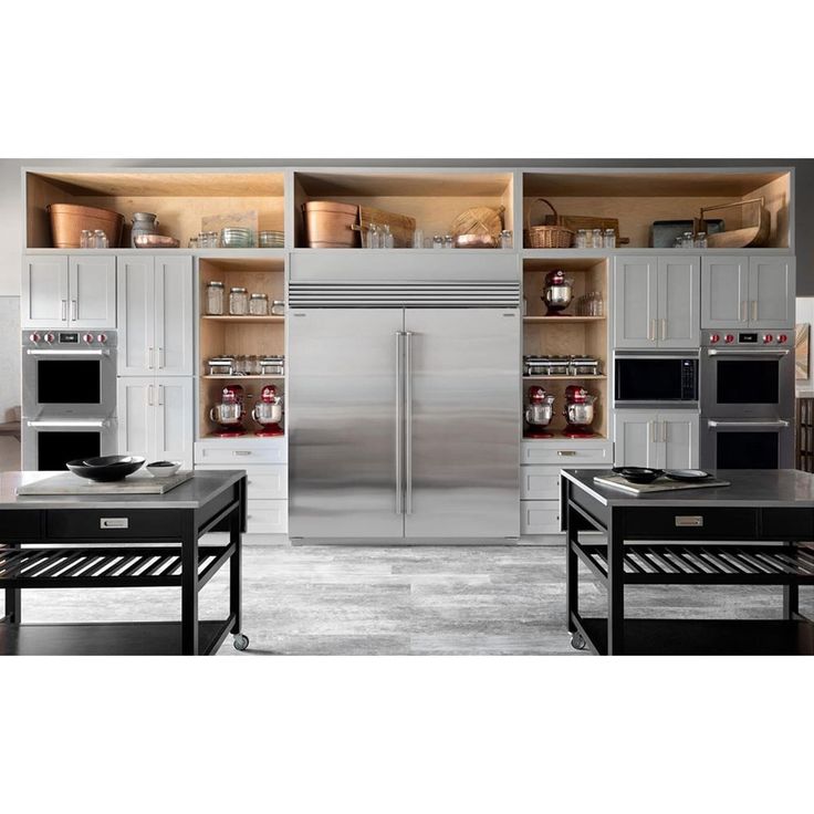 an image of a kitchen setting with stainless steel refrigerators and stoves in it