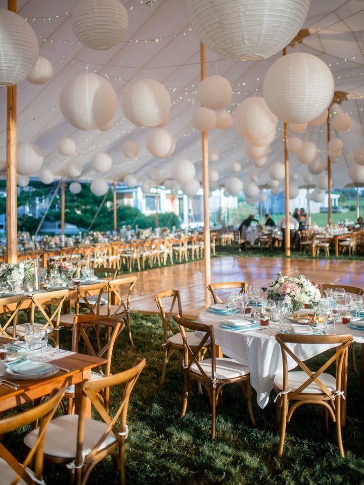 tables and chairs are set up under white paper lanterns