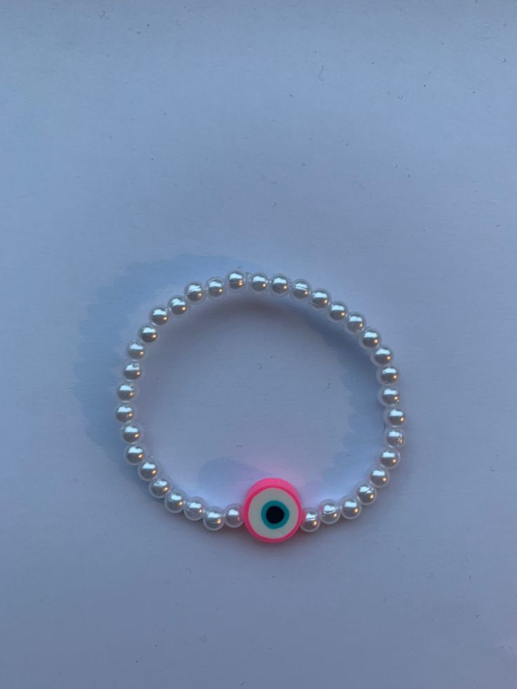 Pearl beaded bracelet with pink evil eye clay bead charm. Select size between 15-22cm. White Evil Eye Beaded Bracelets, White Evil Eye Bracelet With Round Beads, White Beaded Round Evil Eye Bracelet, White Round Beaded Evil Eye Bracelet, Pink Beaded Evil Eye Bracelet With Round Beads, Handmade Pink Evil Eye Bracelet With Round Beads, Pink Beaded Evil Eye Bracelet, White Evil Eye Bracelet With Colorful Round Beads, Pink Evil Eye Bracelet Jewelry