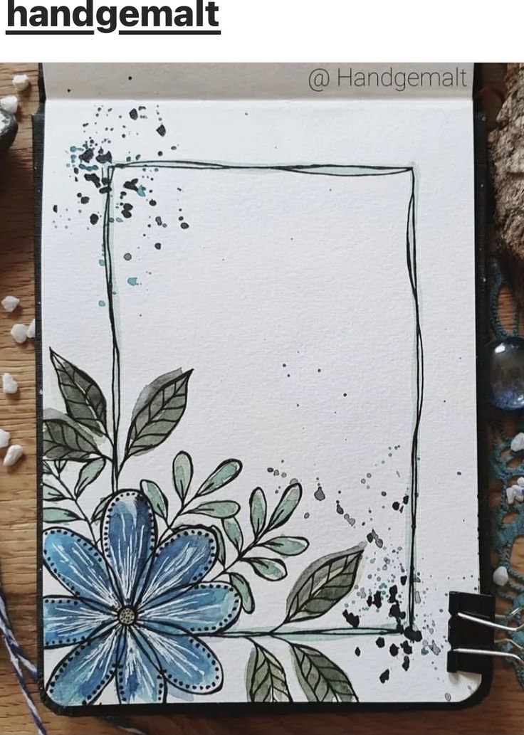 an art journal with watercolor flowers and leaves on the cover, surrounded by other items