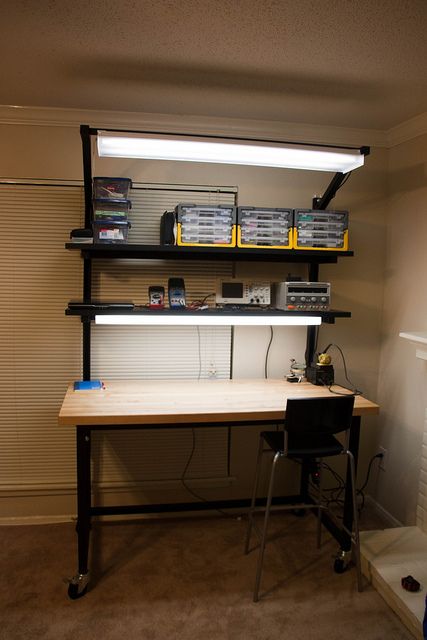 a computer desk sitting under a window in a room