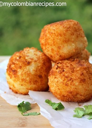 three fried food items sitting on top of a piece of paper next to some parsley