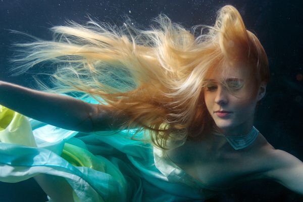 a woman with long hair floating in the water