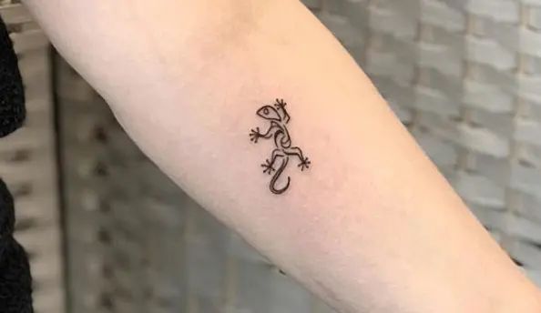 a small lizard tattoo on the arm