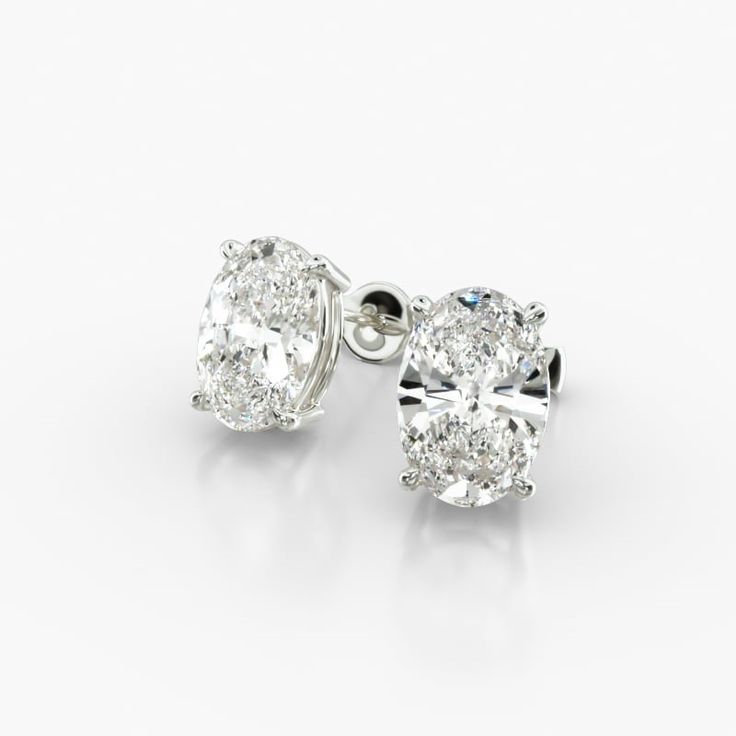 These classic oval-shaped diamond earrings are a timeless and elegant addition to any jewelry collection. The tapered basket setting showcases the unique beauty of the oval-shaped diamonds, which sparkle and shimmer with every move. The earrings are made of high-quality platinum, which is a durable and precious metal that will stand the test of time. Each earring features a single oval-shaped diamond that weighs approximately 2.00 carats in total. The diamonds are near-colorless (H-I color grade Oval Diamond Earrings, Oval Diamond Earring, Tiffany Diamond, Basket Setting, Jewelry Photoshoot, Solitaire Earrings, Oval Earring, Unique Beauty, Diamond Stud Earrings