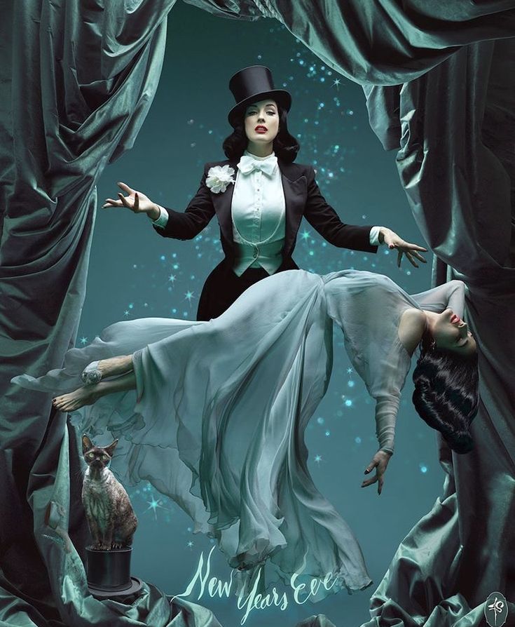 a woman in white dress and top hat standing on stage with her legs spread out