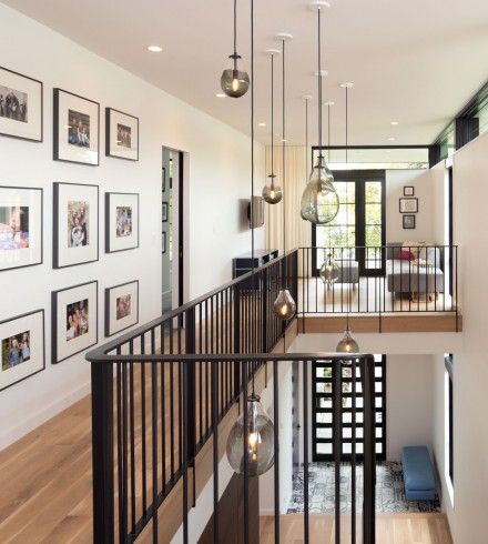 an open floor plan with pictures on the wall and stairs leading up to the second floor