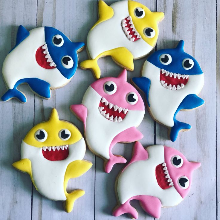 several decorated cookies with different colored sharks on them