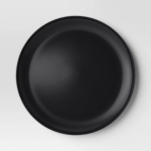 a black plate sitting on top of a white table