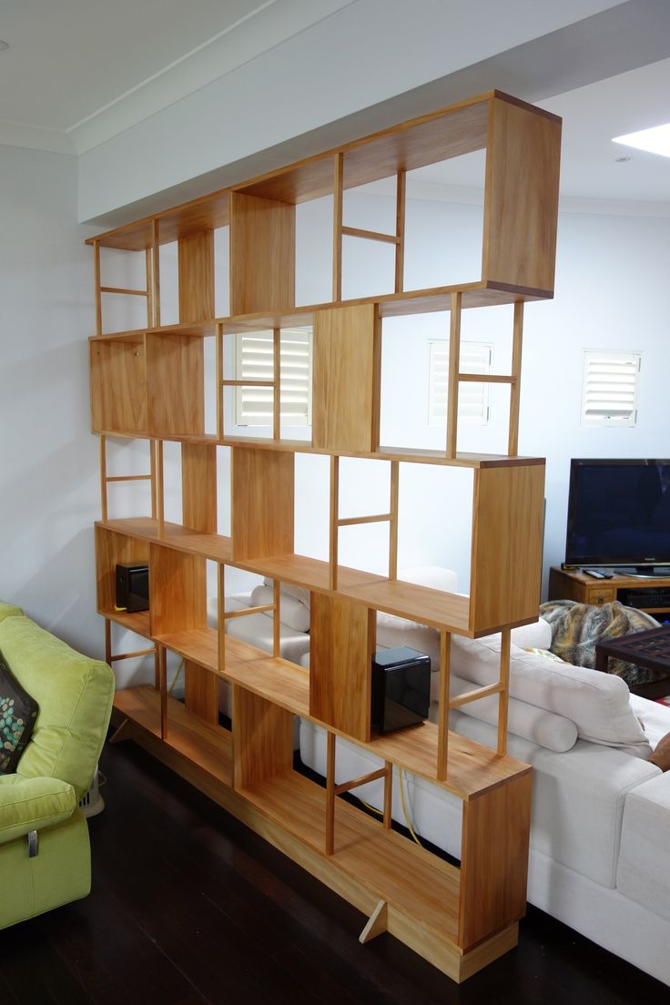 a living room filled with furniture and a flat screen tv on top of a wooden shelf