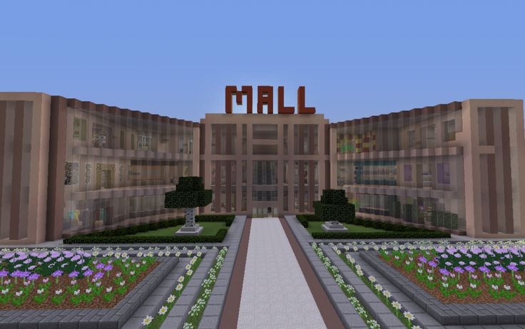 the entrance to a large building with flowers in front of it and a sign that says mall