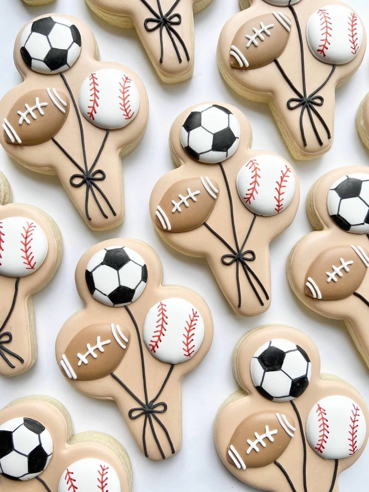 decorated cookies are arranged in the shape of baseballs and soccer balls