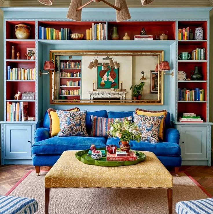 a living room with blue couches and colorful bookshelves