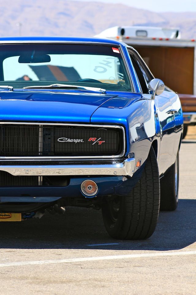 a blue muscle car parked in a parking lot