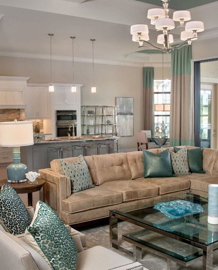 a living room filled with furniture and a chandelier above a glass coffee table