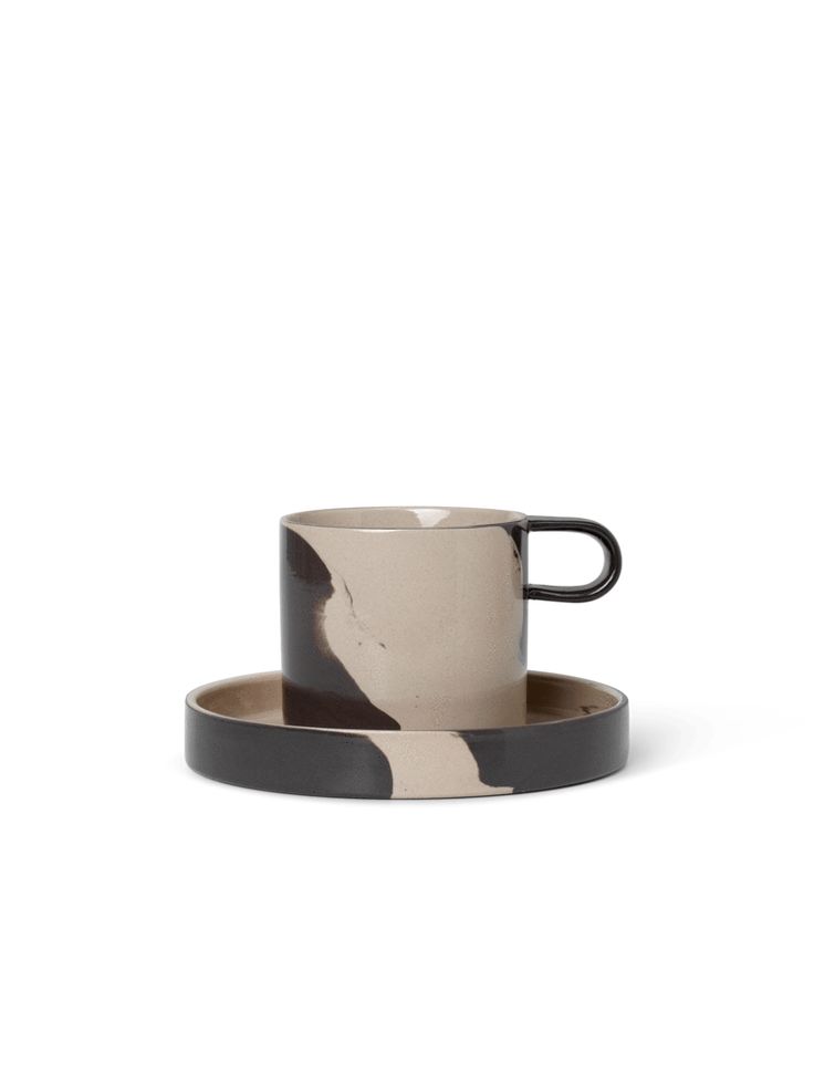 a black and white coffee cup sitting on top of a saucer