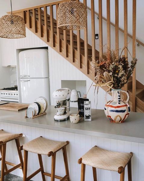 a kitchen with stools and a vase on the counter next to some flowers in a vase