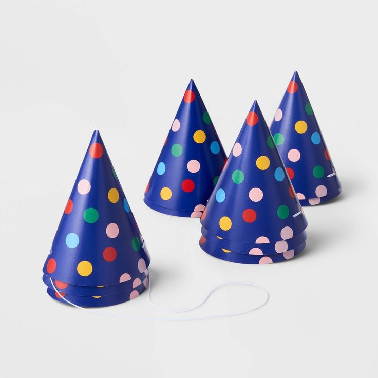 four party hats with multicolored polka dots on them