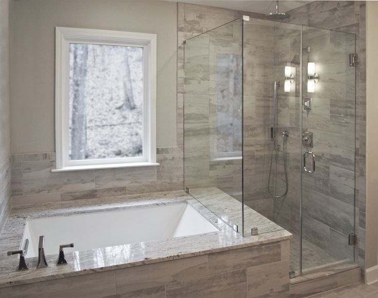 a bathroom with a walk in shower next to a bath tub