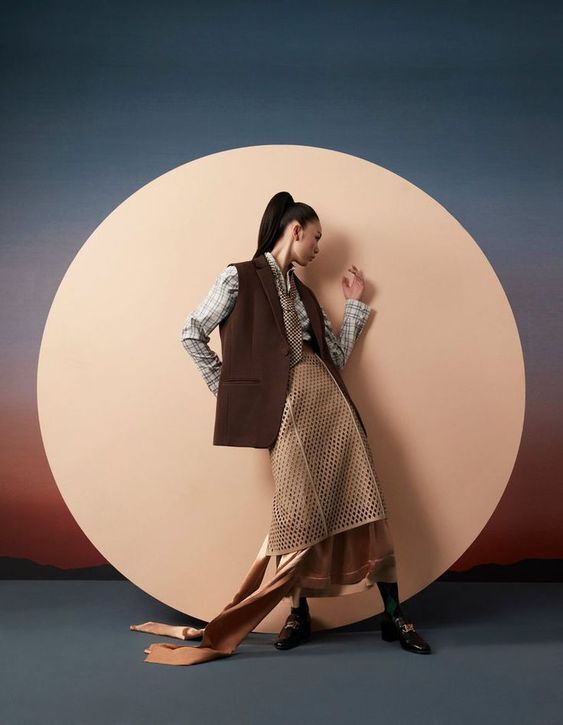 a woman standing in front of a large round object with her hands on her hips