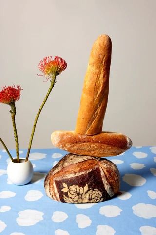 two breads stacked on top of each other in front of some flowers and a vase