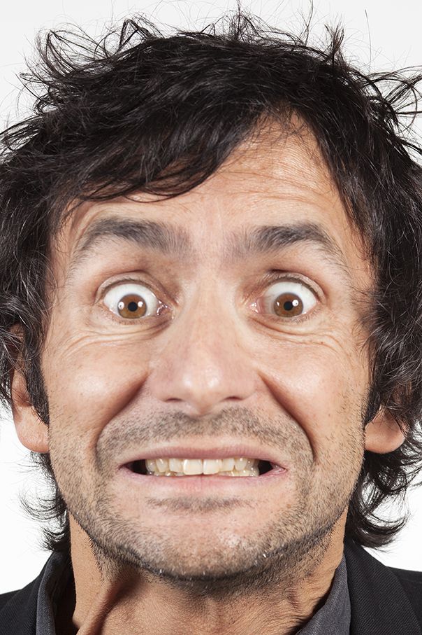 a close up of a person wearing a suit and tie with an odd look on his face