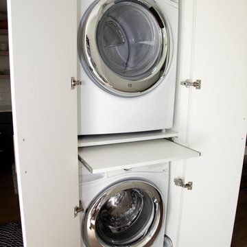 a washer and dryer are stacked in a small closet next to each other