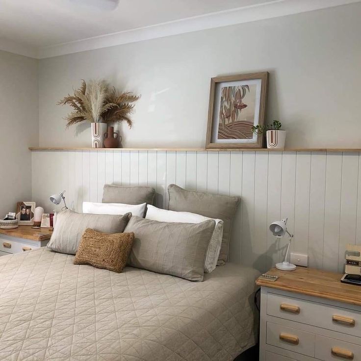 a bed sitting in a bedroom next to a wooden dresser and lamp on top of it