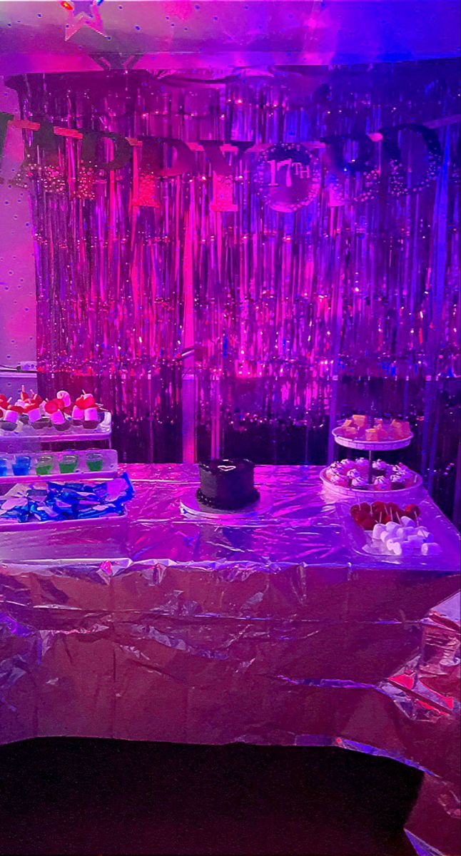 a table covered in plastic with cakes and cupcakes on it at a party