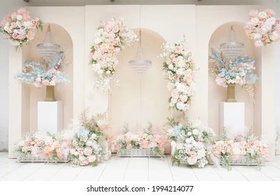 three white vases filled with flowers on top of a tiled floor next to wall